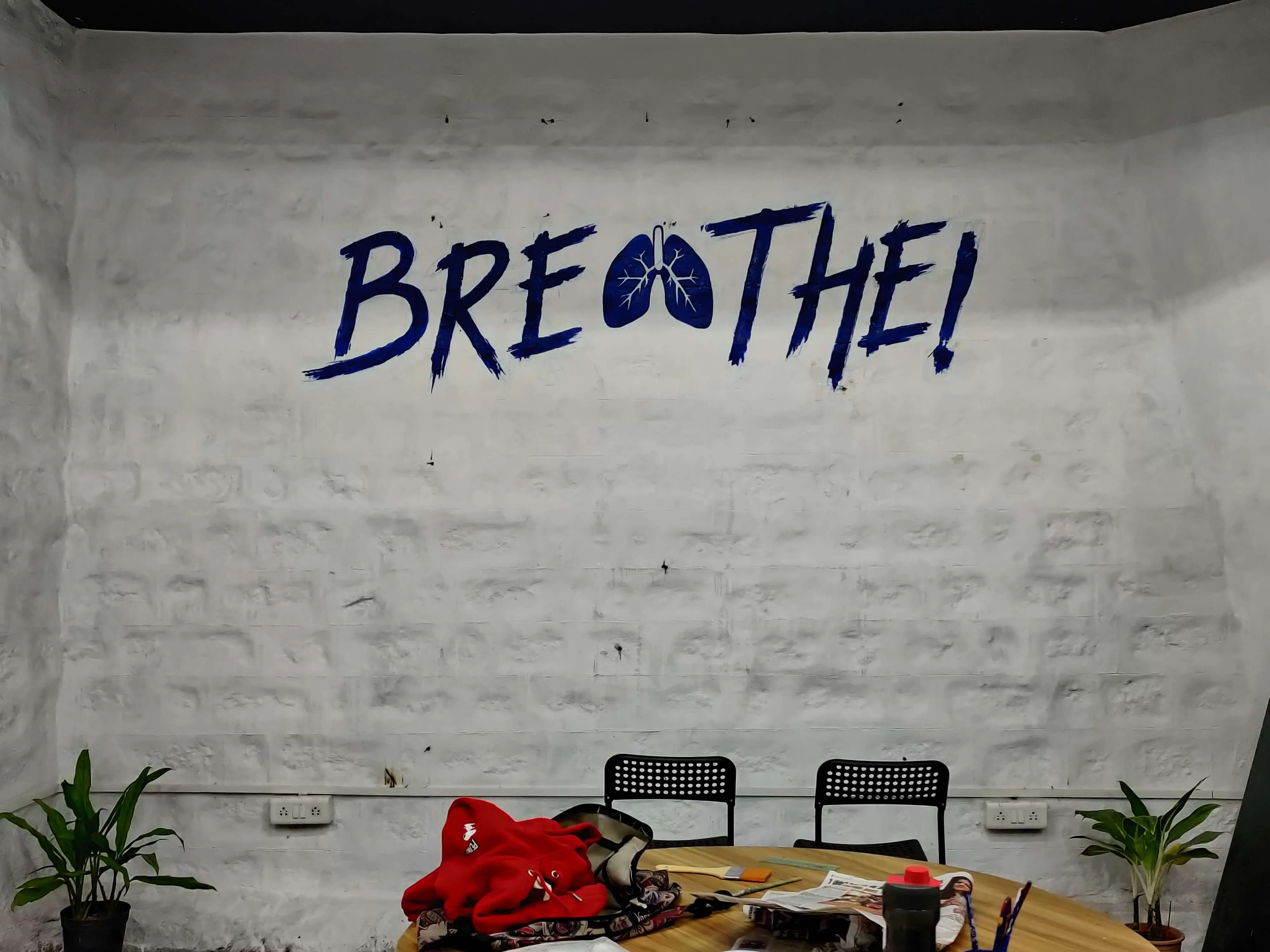 Mural of the words 'BREATHE' where the 'A' looks like human lungs.